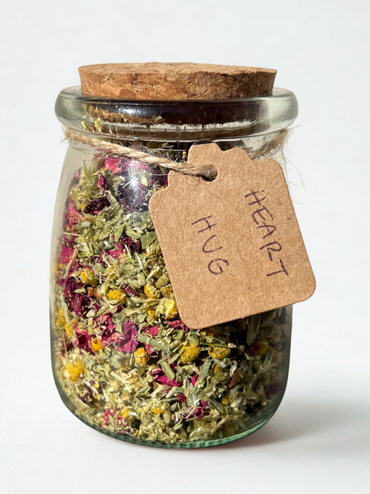 front-facing shot of Ophelia’s Breath’s heart hug tea in glass jar — crafted with oatstraw, rose, and kanna for emotional release and womb support. Wholesale and bulk options available for organic teas.