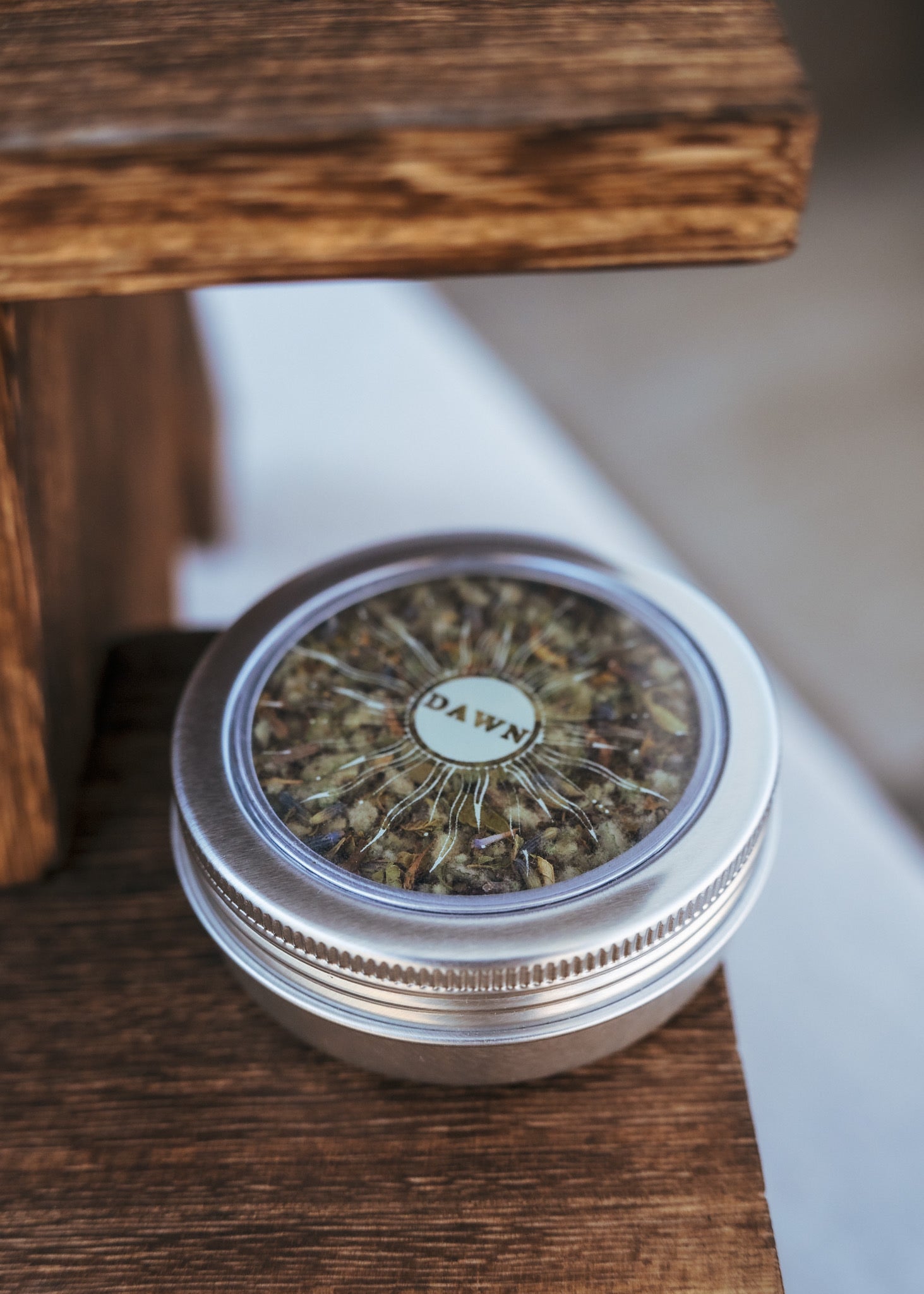 A product image of Ophelia’s Dawn herbal  smoking blend in a circular aluminum tin, made with organic sceletium tortuosum. Kanna products are available for wholesale or bulk purchase.